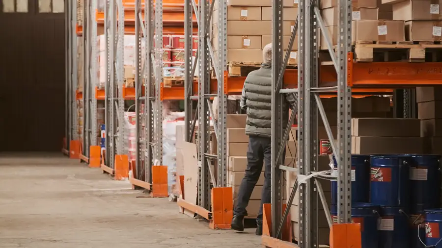 Un préparateur attrapant un carton dans les allées d'un entrepôt